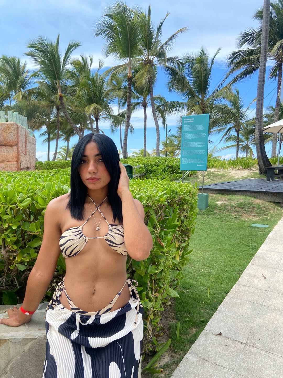 Woman in a beach wrap standing by palm trees