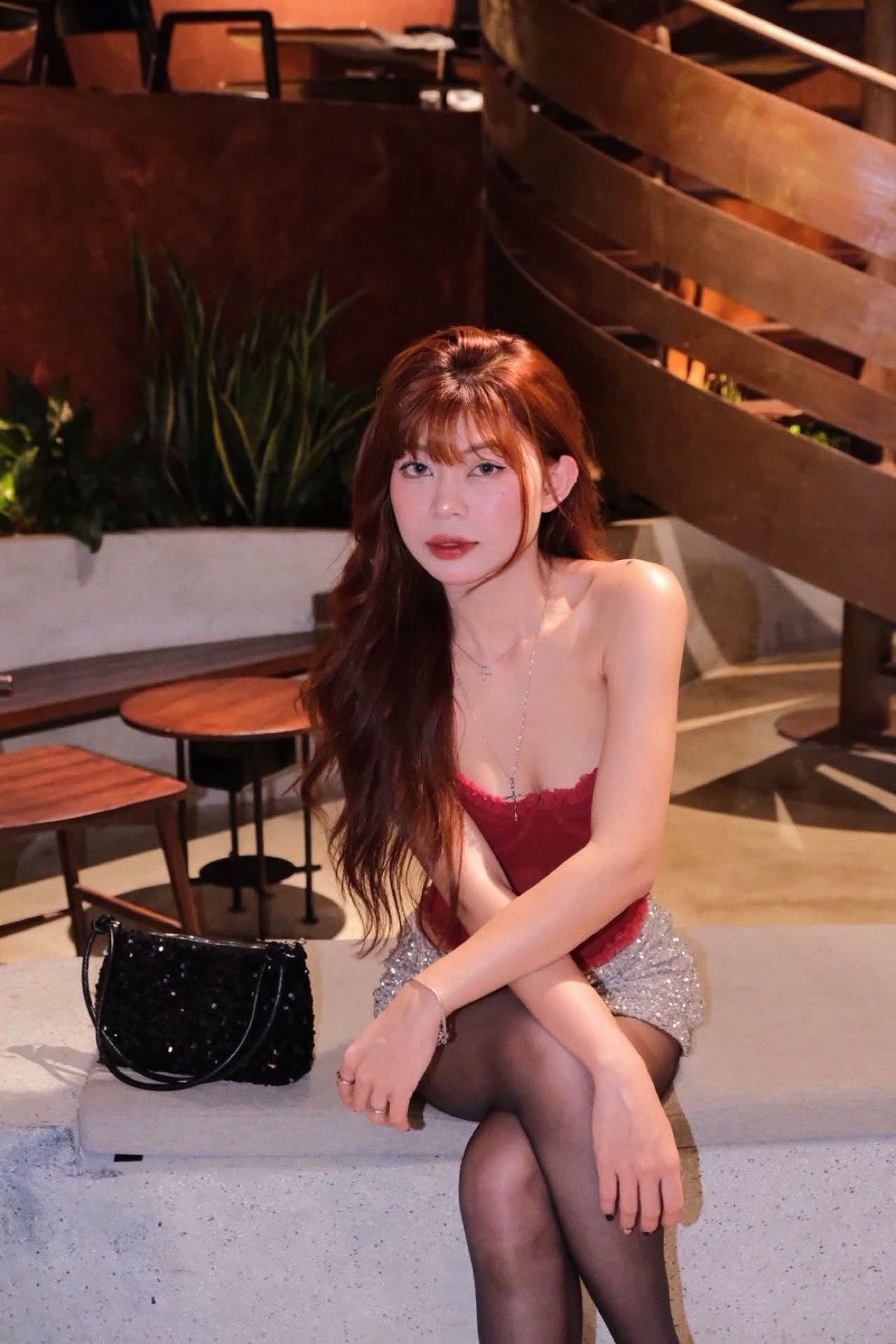 Woman in a red top sitting at an outdoor café