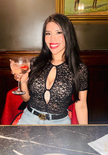 Woman in black lace holding a glass at a restaurant