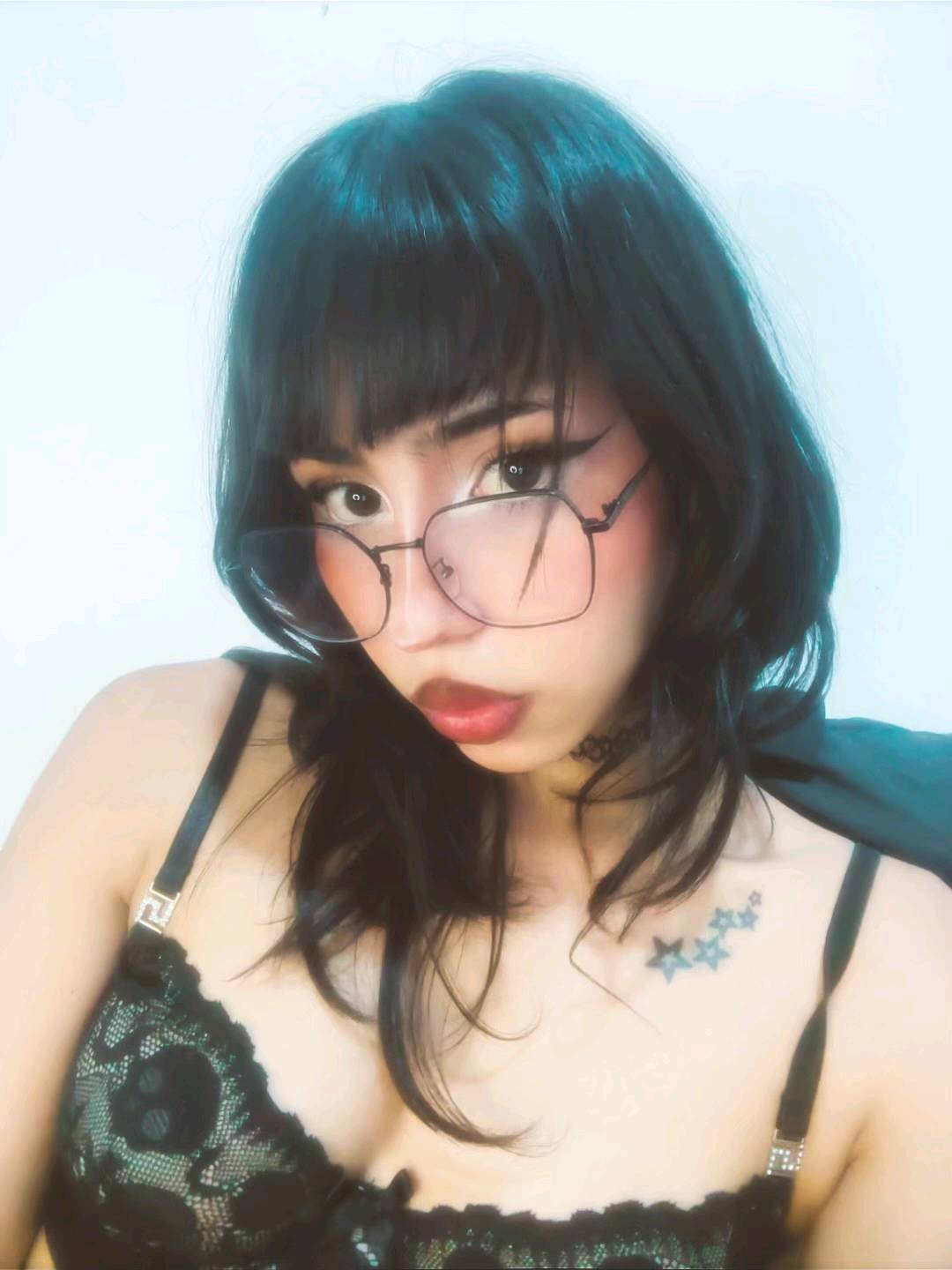 Woman with glasses and short dark hair in black lace